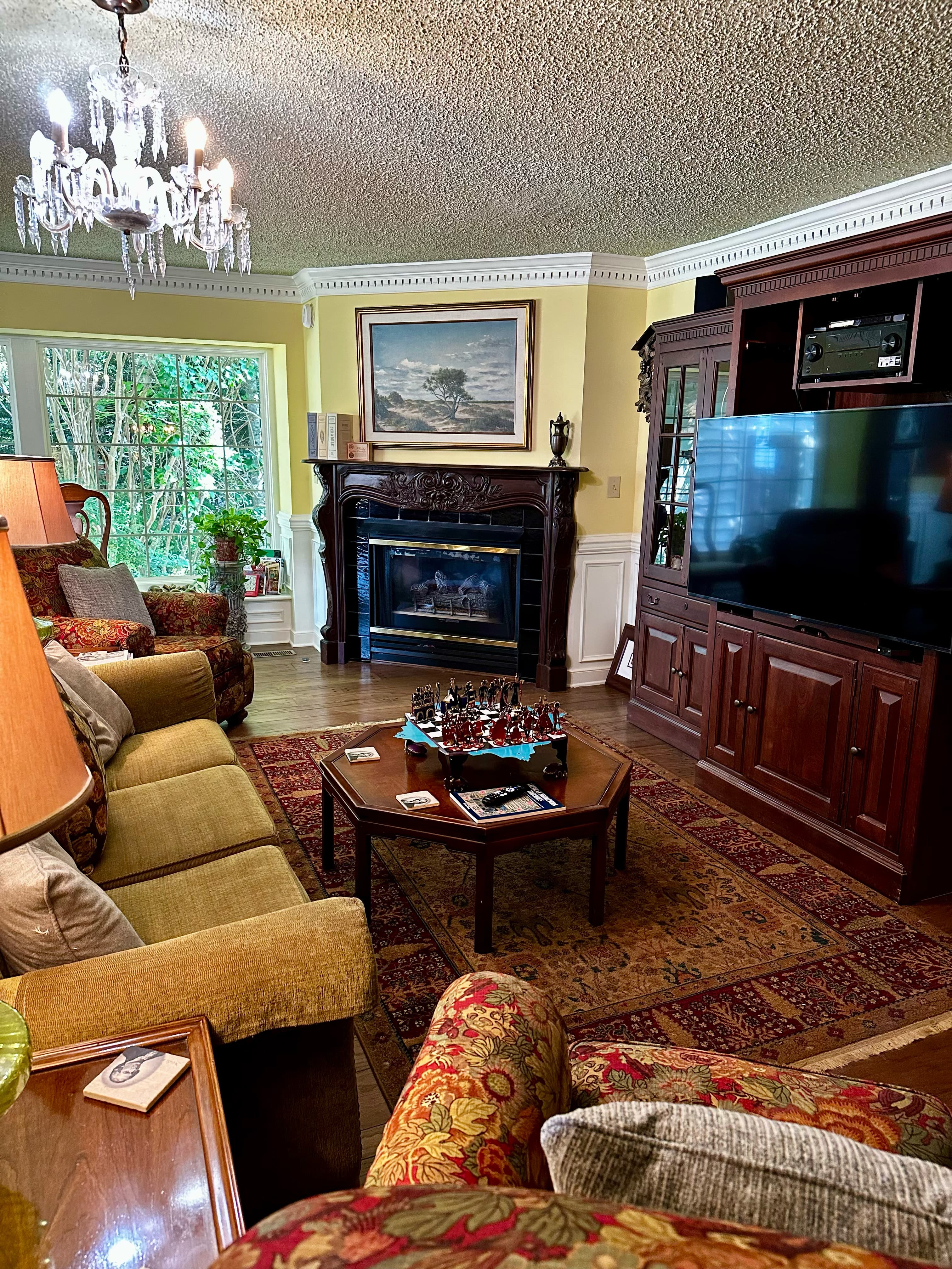 Cozy living room with a fireplace, large TV, and a chess set on the coffee table.
